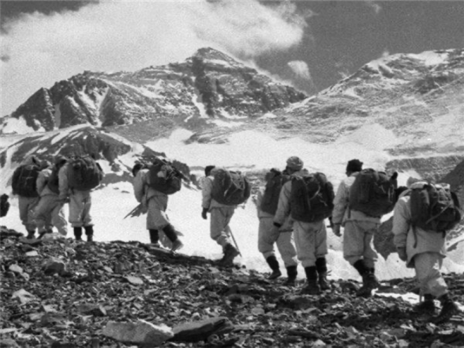 我国登山队队员们向珠穆朗玛峰（远处最高的山峰）前进。.png