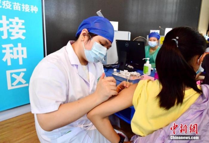 图为福州第四十中学金山分校疫苗接种点,医务人员正在为学生接种新冠疫苗。张斌 摄 点击进入下一页