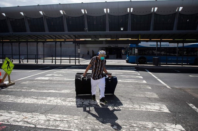 1628166344969725.jpg 资料图:美国弗吉尼亚州,乘客们戴着口罩抵达杜勒斯国际机场。(图源:人民视觉)_副本.jpg