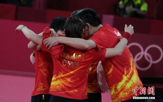 8月5日晚,在东京奥运会女乒团体决赛中,由陈梦、孙颖莎、王曼昱组成的中国队3:0战胜日本队,获得冠军。图为赛后女队主教练李隼(右)与队员拥抱。<a target='_blank' href='http://www.chinanews.com/'>中新社</a>记者 杜洋 摄 点击进入下一页