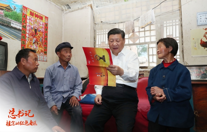 2017年6月21日下午,习近平在忻州市岢岚县赵家洼村特困户刘福有家中察看扶贫手册。