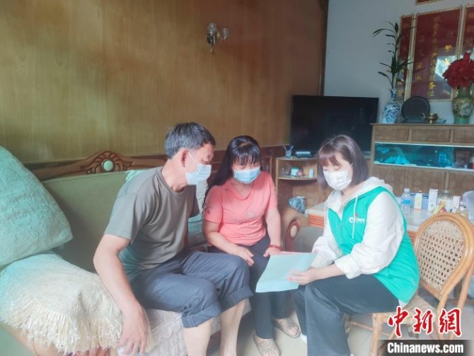 图为杨玉玲(右一)向社区居民发放防疫资料。 李斯文 摄 图为杨玉玲(右一)向社区居民发放防疫资料。 李斯文 摄