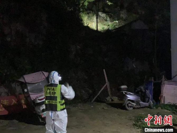 移民管理警察用手电筒照射巡视山坳。 韦德富 摄 移民管理警察用手电筒照射巡视山坳。 韦德富 摄