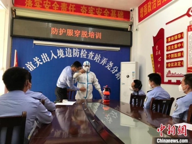 移民管理警察开展防护服穿脱培训。 肖杰 摄 移民管理警察开展防护服穿脱培训。 肖杰 摄