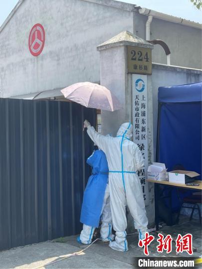 志愿者为吴贝贝撑起一把伞。 复星供图 志愿者为吴贝贝撑起一把伞。 复星供图