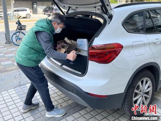 普陀区长征镇建二居民区党总支书记王荣寿正在给车辆消毒 受访者供图 普陀区长征镇建二居民区党总支书记王荣寿正在给车辆消毒 受访者供图