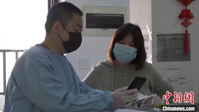 松江区永丰街道玉荣居民区党总支书记叶菊丽(右)正与志愿者沟通小区发放物资事宜 受访者供图 松江区永丰街道玉荣居民区党总支书记叶菊丽(右)正与志愿者沟通小区发放物资事宜 受访者供图