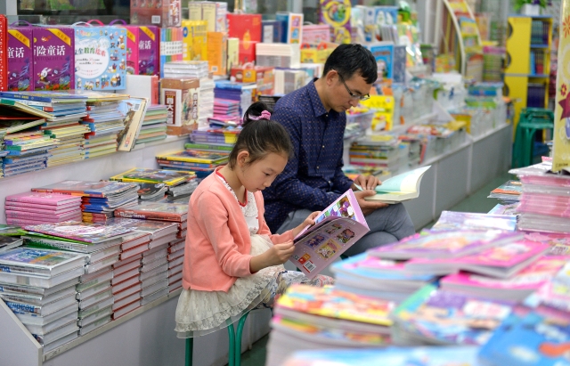 暑期里，家长带着孩子在书城里看书。本报记者 龙宇丹 实习生 王庆杰 摄