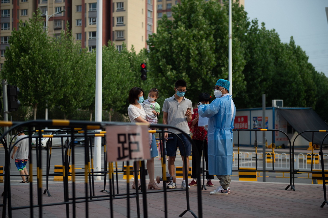 6月3日，张旭（右一）引导前来进行核酸采样的居民扫描北京健康宝。新华社记者 陈钟昊 摄