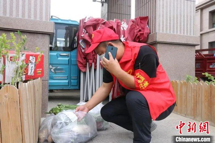 一名志愿者正在为居民配送生活物资。 张馨予 摄 一名志愿者正在为居民配送生活物资。 张馨予 摄