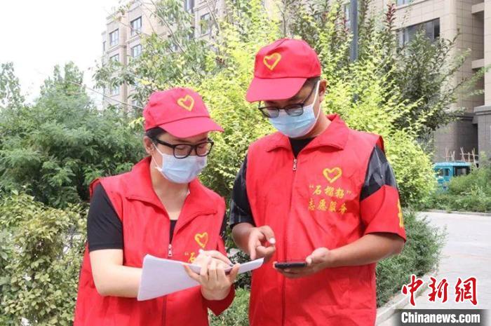 两名志愿者商量为小区居家休息人员配送物资事宜。 张馨予 摄 两名志愿者商量为小区居家休息人员配送物资事宜。 张馨予 摄