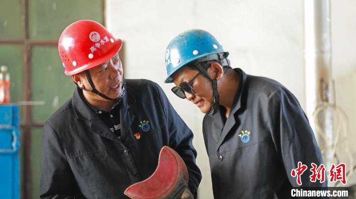 图为旦增顿珠(左)与同事进行技术交流。 旦增顿珠本人供图