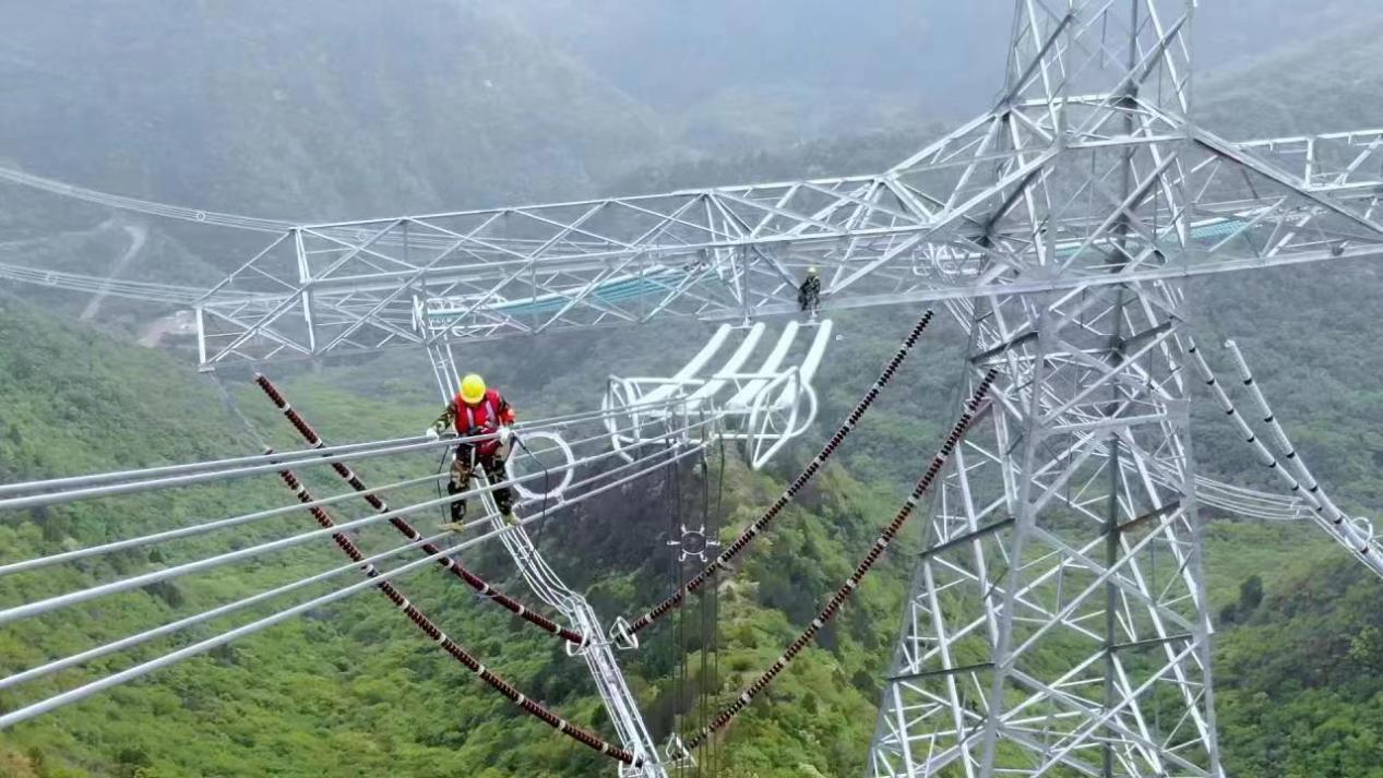 崇山峻岭间,特战班成员在高120米、直径11公分左右的导线上作业。(图片由国网山西超高压输电公司提供)