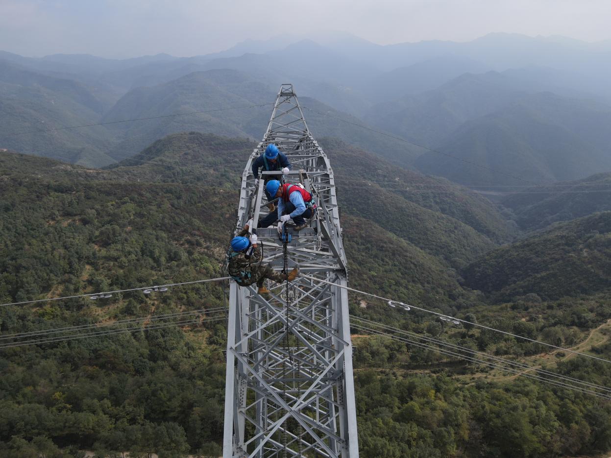 70米高的铁塔,郝晨飞与队员们在塔顶进行作业。(图片由国网山西超高压输电公司提供)