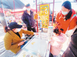 游客在官渡古镇买糖画。 记者刘凯达摄