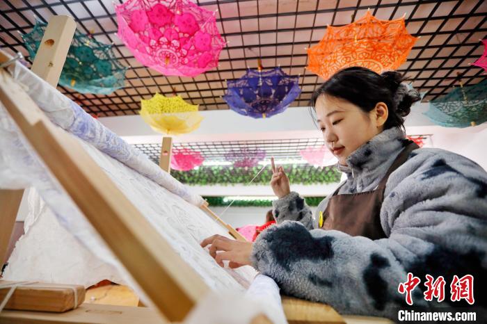 秀工在图样上进行手工刺绣。 陈阳 摄 秀工在图样上进行手工刺绣。 陈阳 摄