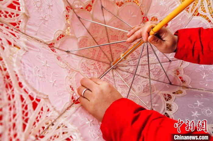 工人正在固定伞架。 陈阳 摄 工人正在固定伞架。 陈阳 摄