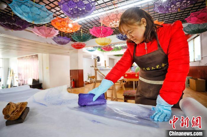 秀工在手工印刷花边伞图样。 陈阳 摄 秀工在手工印刷花边伞图样。 陈阳 摄