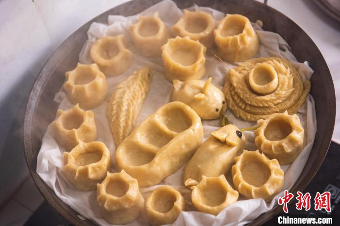 制作“面灯”需要先用面团做成各种形状,上锅蒸熟。 陈光金 摄 制作“面灯”需要先用面团做成各种形状,上锅蒸熟。 陈光金 摄