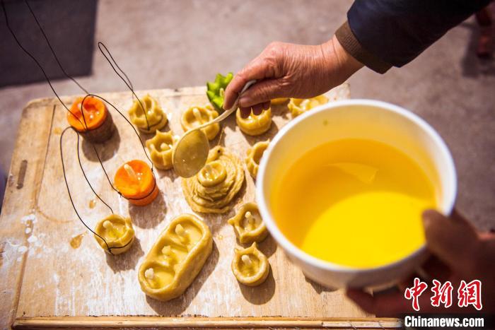 正在往蒸好的面灯内加入食用油。 陈光金 摄 正在往蒸好的面灯内加入食用油。 陈光金 摄