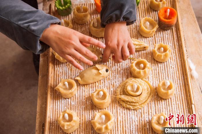 村民在面灯内插上灯芯。 陈光金 摄 村民在面灯内插上灯芯。 陈光金 摄