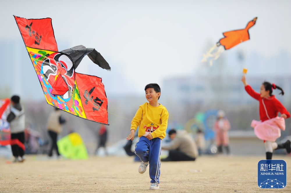 3月26日,小朋友在山东省滕州市市民广场放风筝.