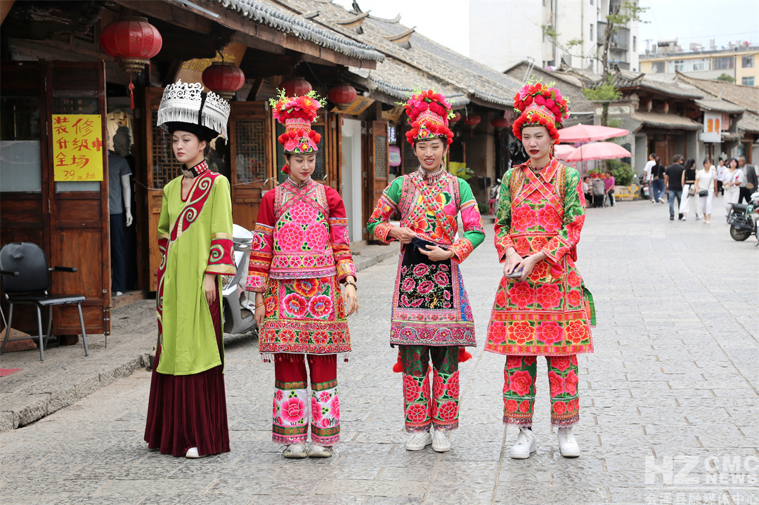 10位身着彝族服饰的姑娘漫步老街,流连深巷,与古建筑物亲密接触,寻觅