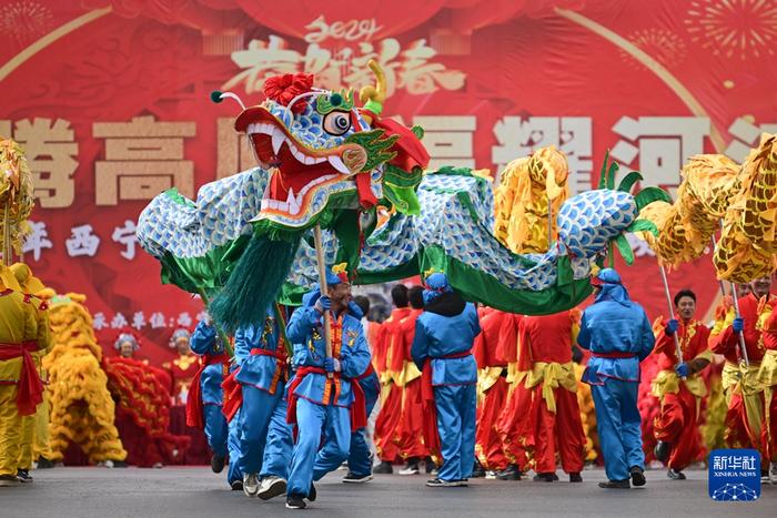 2月19日,在青海省西宁市,舞龙队员在社火巡游活动中表演。新华社记者 张龙 摄