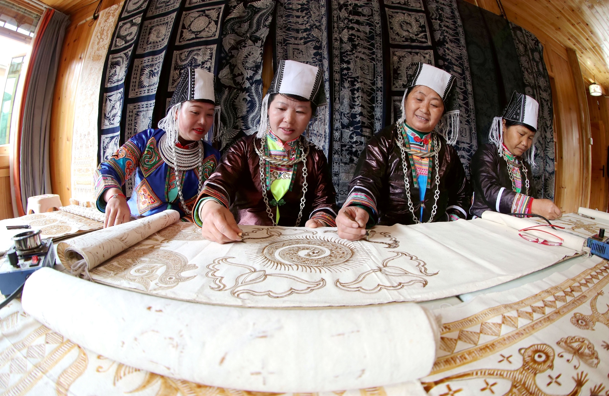 1709992571144697.jpg 715878-2024年3月6日,在贵州省黔东南苗族侗族自治州榕江县三江乡冷衣村,苗族妇女在画蜡画。.JPG