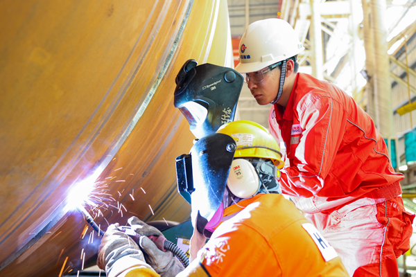 王佳鑫（右）和同事正在进行焊接作业。受访者供图