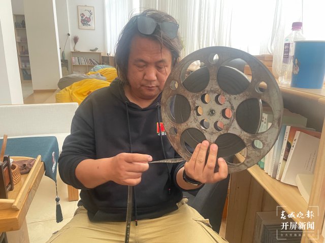 杨峰在展示胶片如何放映.jpg