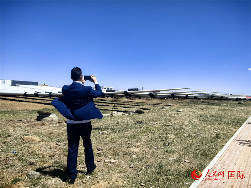 外媒记者拍摄厂房外的风力涡轮发电机的巨型浆叶。人民网 杨春燕摄