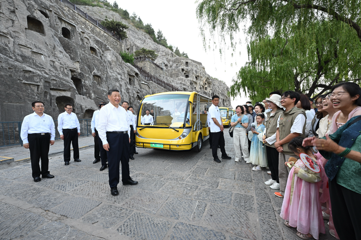5月19日，习近平在洛阳龙门石窟考察时，同游客亲切交流。