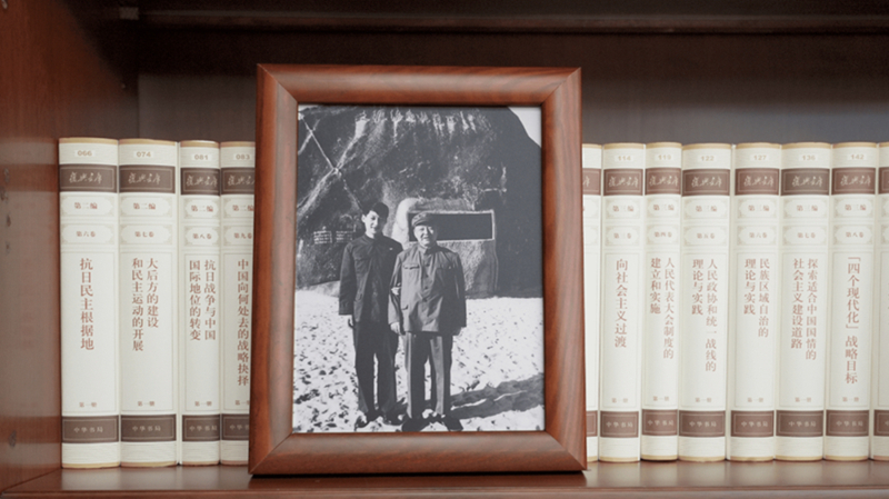 2022年12月31日,习近平办公室的书架上摆放着他和父亲的合影。
