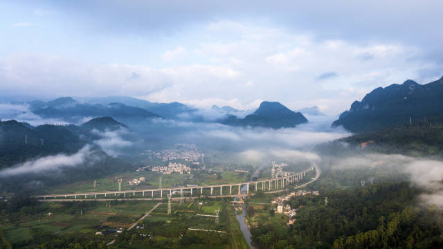 广东清远阳山县，高速公路绕过村庄，清晨云雾缭绕，远看十分壮观。南方+记者 冯国志 摄