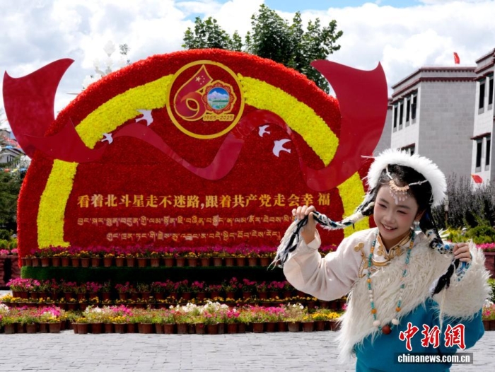 8月19日，随着西藏自治区成立60周年庆祝活动临近，拉萨氛围浓。拉萨街头，处处是张灯结彩的盛景，洋溢着一派祥和与欢腾的氛围。图为游客在拉萨大昭寺广场上的大庆宣传标语前留念。<a target='_blank' href='/'>中新社</a>记者 李林 摄