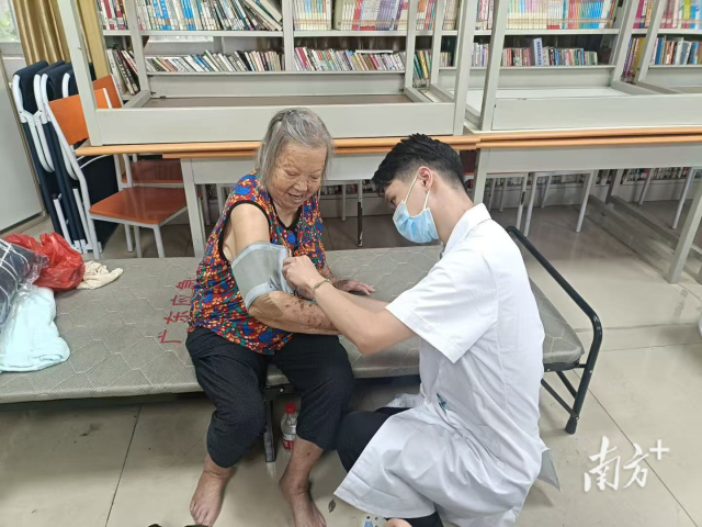 安置点内，医生正在为转移群众测量血压。冯飘洁 摄