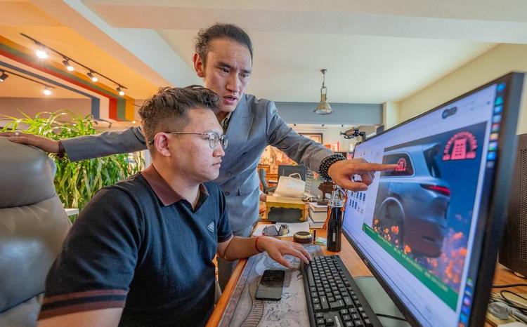 Tashi Badan (rear) discusses the product design plan with a colleague at Yakhore Design Company in Lhasa, southwest China's Xizang Autonomous Region, Sept. 16, 2025. (Xinhua/Tenzin Nyida)