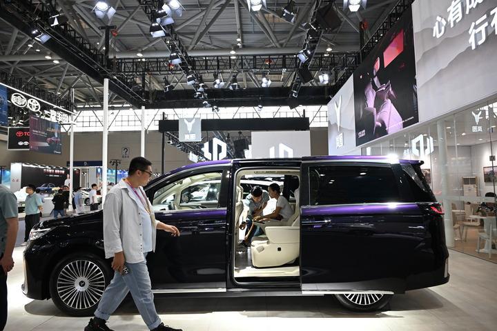 A visitor learns about a new energy vehicle during the World Smart Industry Expo 2025 in southwest China's Chongqing Municipality, Sept. 5, 2025.