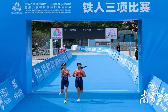 2025年11月27日，杨晓婷在引导员谭嘉怡的牵引下，完成“残特奥会”铁人三项比赛。