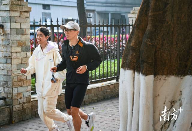 12月5日，许兴群（左）与陪跑员李昀丰（右）一起跑步。