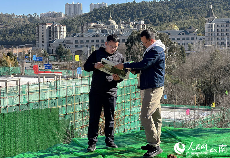 张弟（左）在温泉街道一酒店建设项目现场踏勘。人民网记者 程浩摄