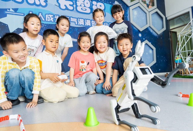 孩子们在操控智能机器狗进行表演 孩子们在操控智能机器狗进行表演