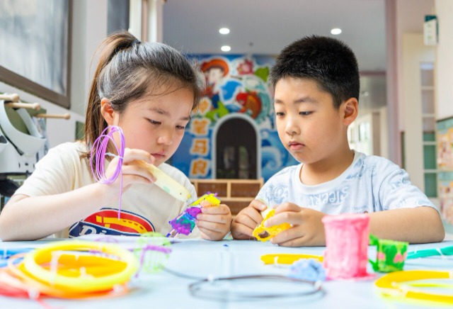 孩子们正聚精会神地使用3D打印笔进行创意制作 孩子们正聚精会神地使用3D打印笔进行创意制作
