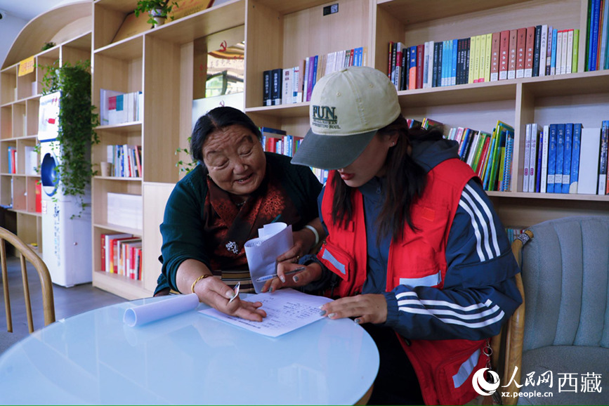 幸福社区的网格员协助老人填写双联户档案表。人民网记者 次仁罗布摄 幸福社区的网格员协助老人填写双联户档案表。人民网记者 次仁罗布摄