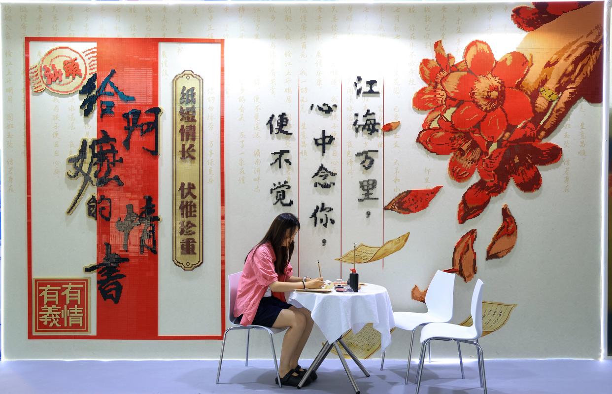 游客在《给阿嬷的情书》电影主题积木打卡墙前体验写批。来源：央视网
