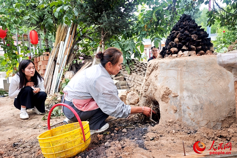 王绿瑞正在给游客制作当地美食。人民网记者 阎梦婕摄 王绿瑞正在给游客制作当地美食。人民网记者 阎梦婕摄