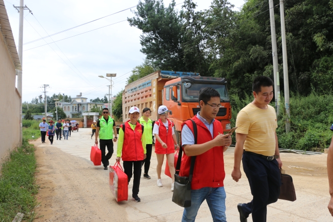志愿者带着慰问品进村 志愿者带着慰问品进村