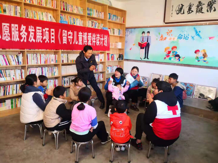 志愿者谭礼等带着孩子读书