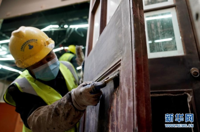 1月14日，工人在清理打磨门面上的木线条。